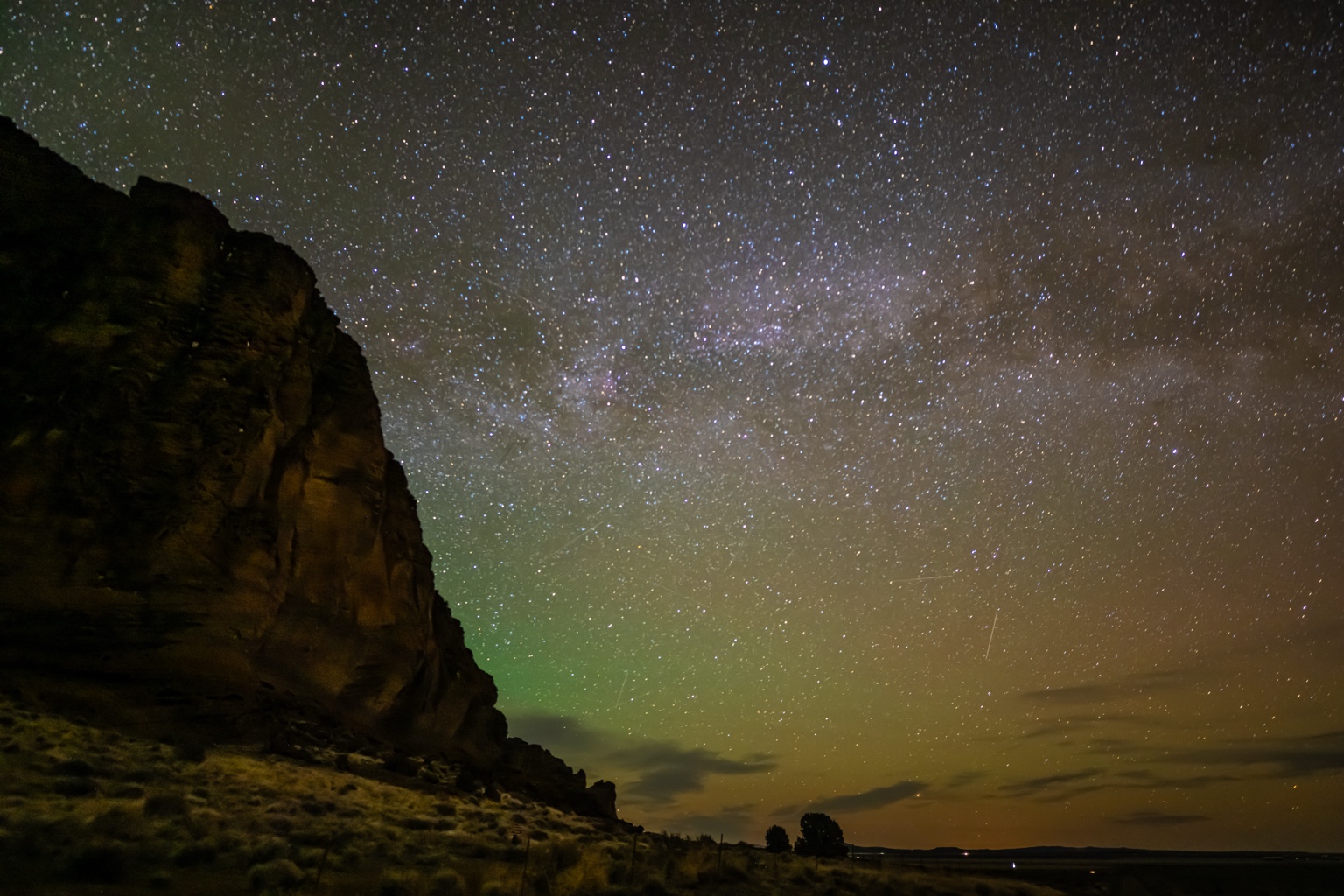 Dark desert cliffs silhouetted against a starry sky
